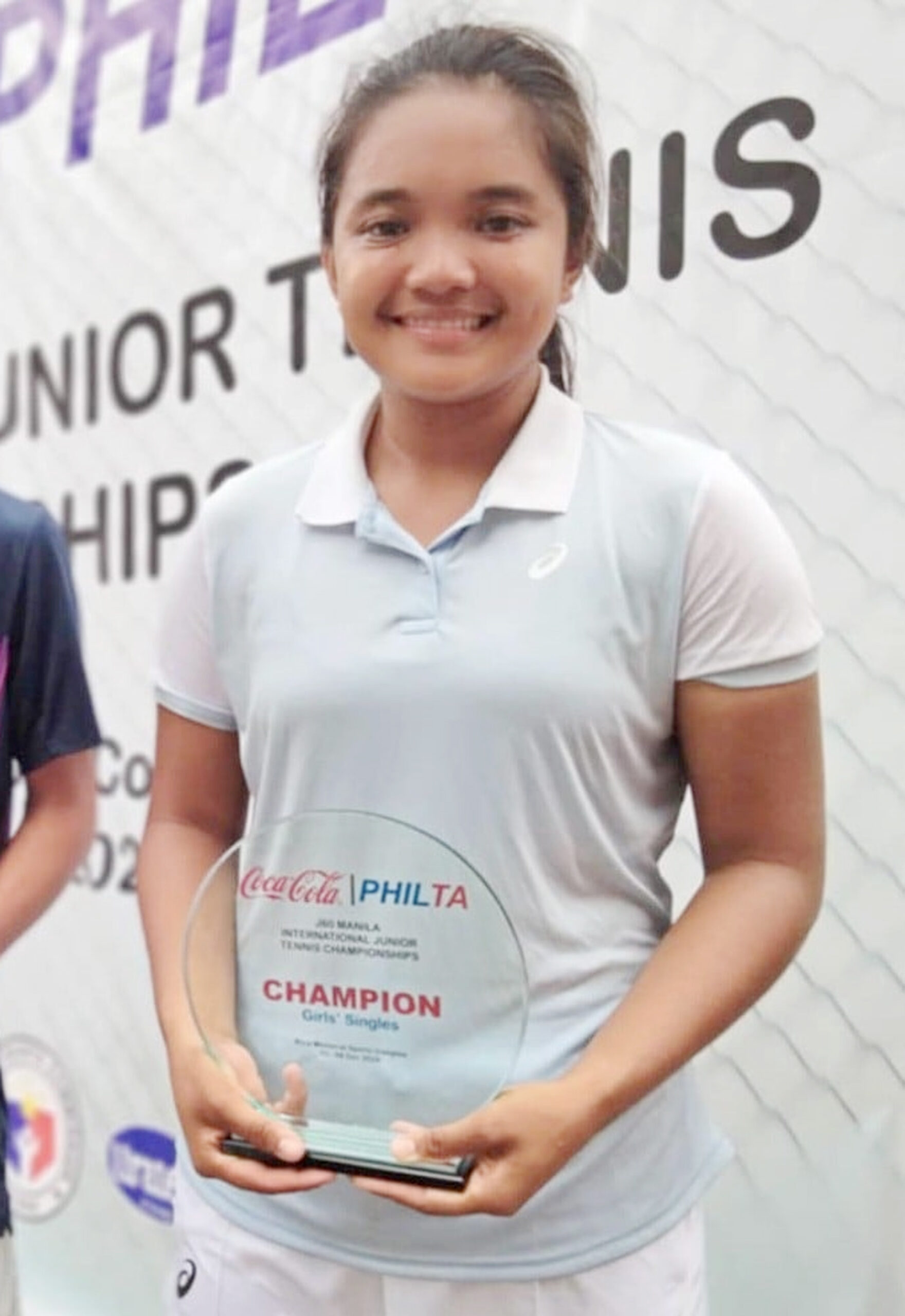 CHAMP: Tenielle Madis of the Philippines holds her trophy during the awarding rites. Madis also won the doubles with Stefi Marithe Aludo.