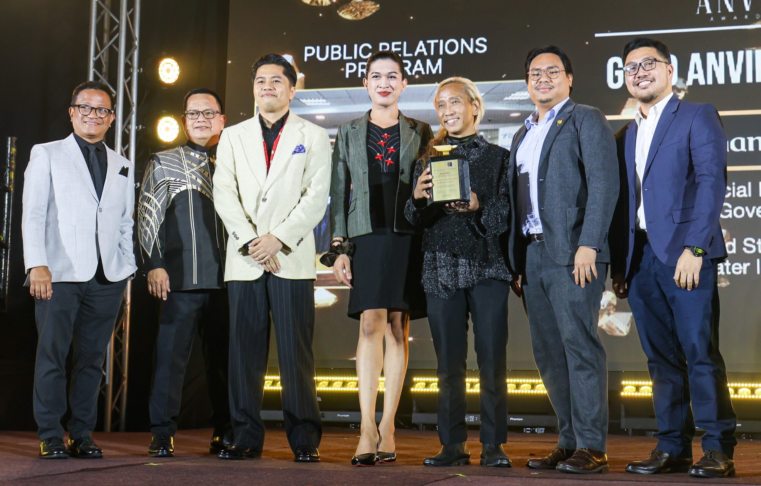 Receiving TP’s Gold Anvil trophy were, third from left, External Relations Supervisor Lorenzo De Leon, Wellbeing Specialist Janna Dasigan, Organizational Development Senior Manager Hector Miranda, Brand Communications Manager Domar Balmes, and Media Relations Manager Adrian Elumba. Also in photo are PRSP Officers Norman Agatep and Andy Saracho.