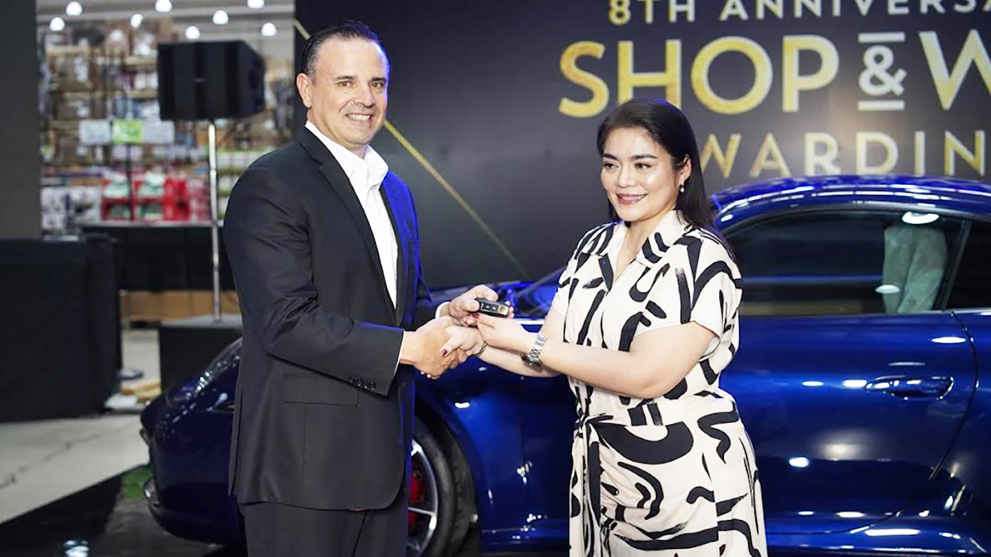 Landers Superstore Chief Transformation Officer Bill Cummings turns over the key to a brand-new Porsche 911 Carrera S to Ms. Ingrid Rose Panuncialman, a lucky winner from Landers Alabang, during the Grand Shop & Win Raffle Awarding Ceremony.