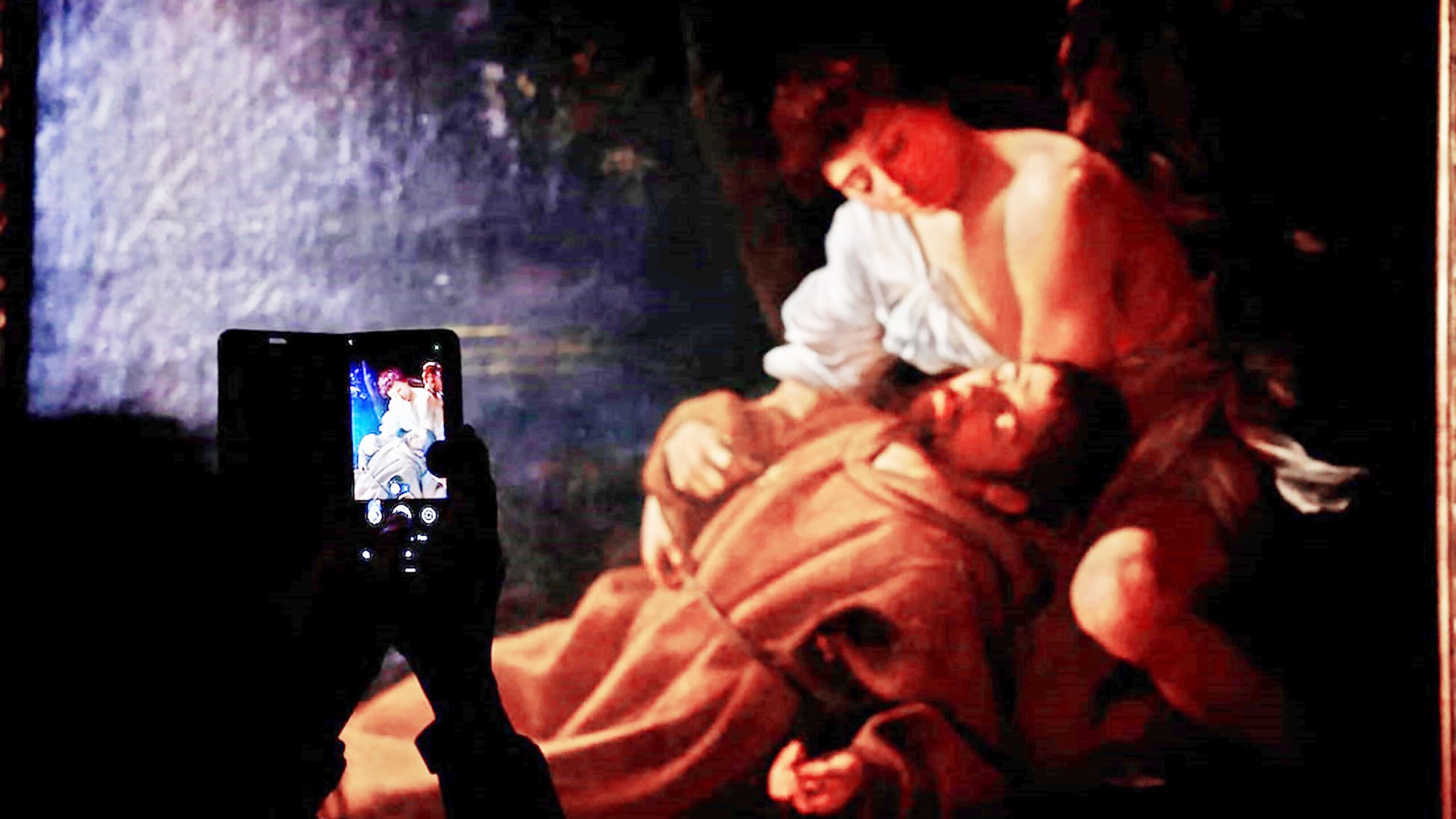 A person takes a picture of a painting by artist Michelangelo Merisi da Caravaggio at the Caravaggio 2025 exhibition at Palazzo Barberini, in Rome, Italy.